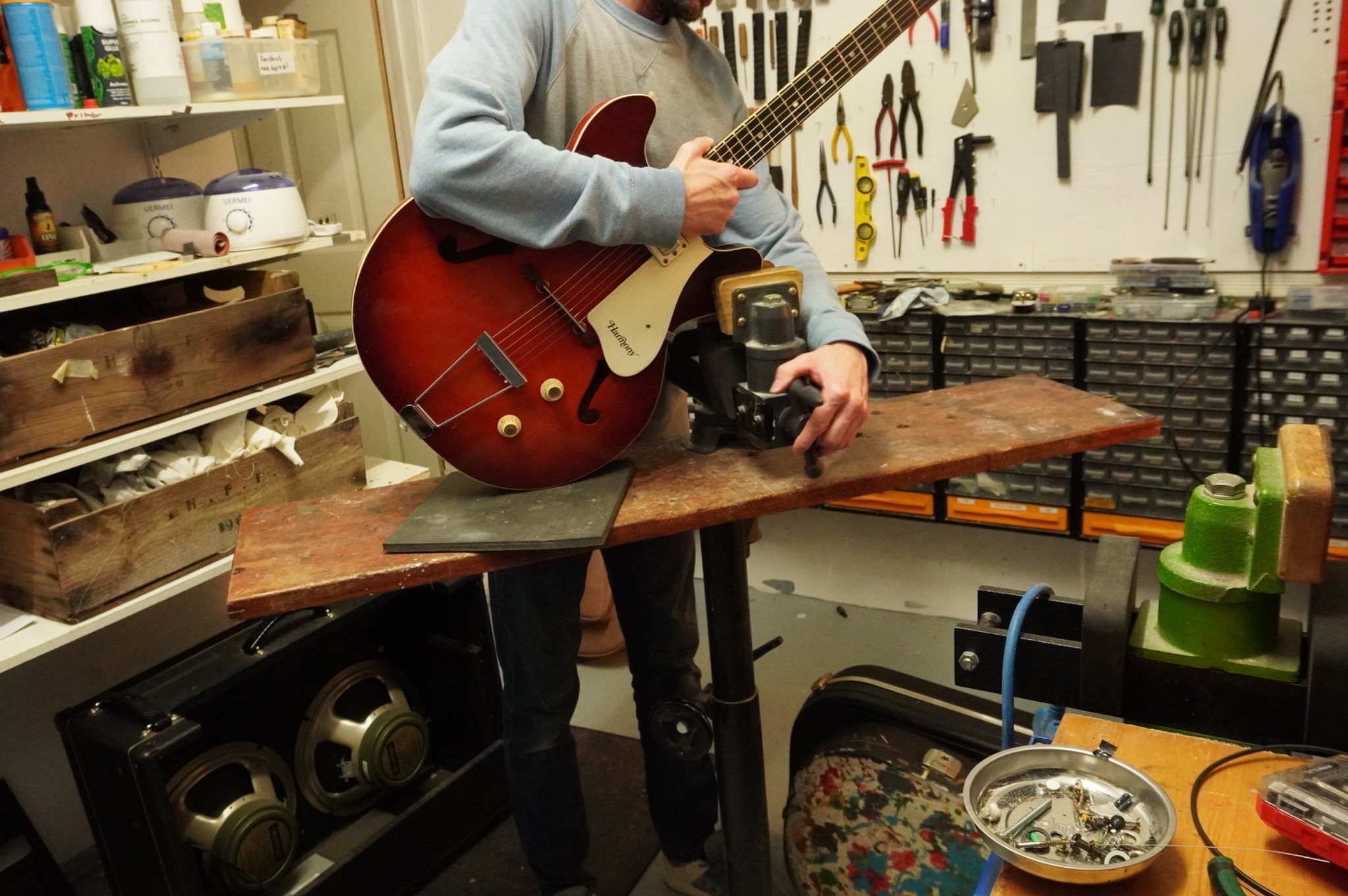 Harmony Rocket being handled at the padded workshop guitar support