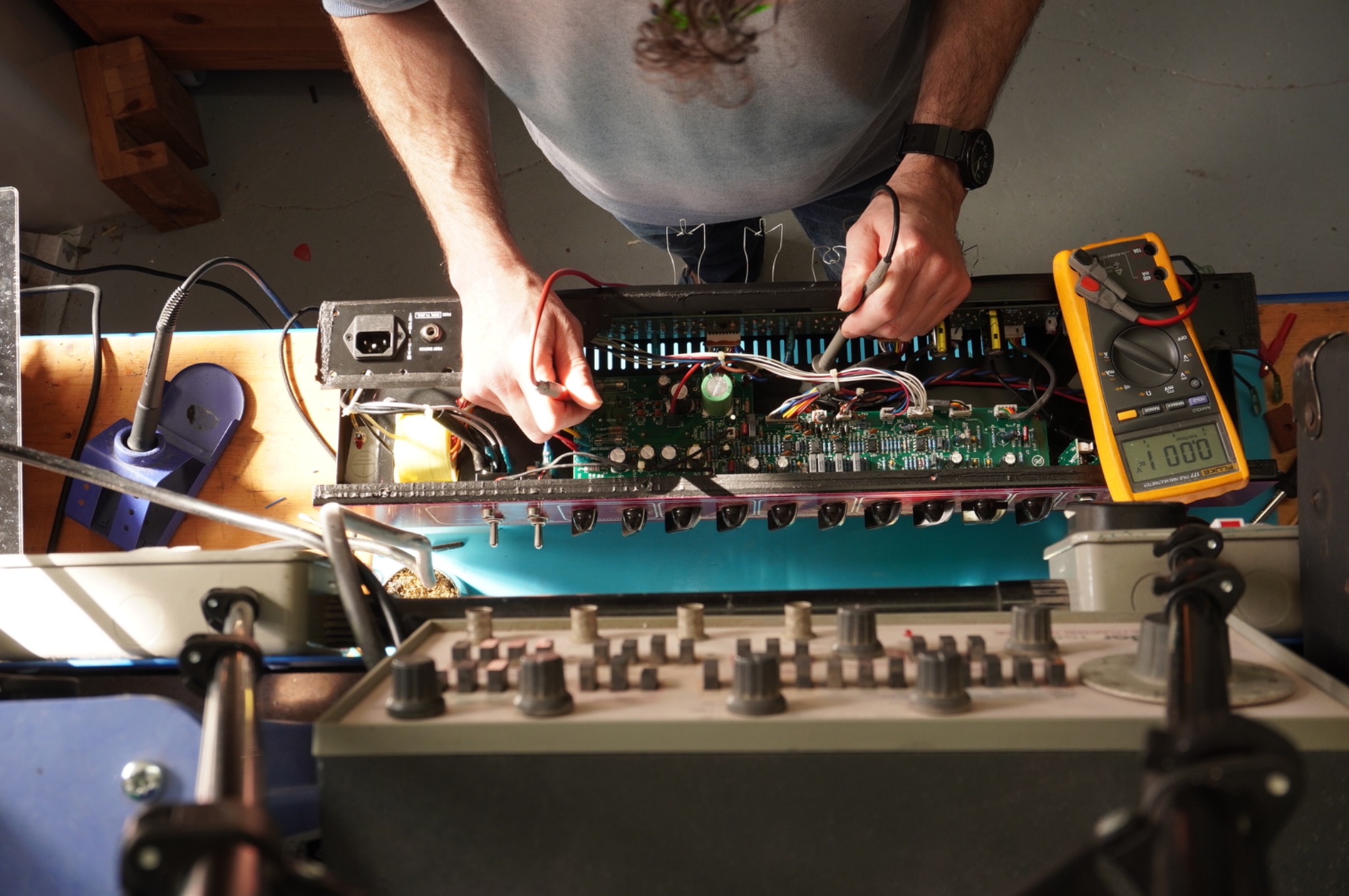 Andrew measuring inside the open Vox AC30 amplifier chassis at the workshop bench